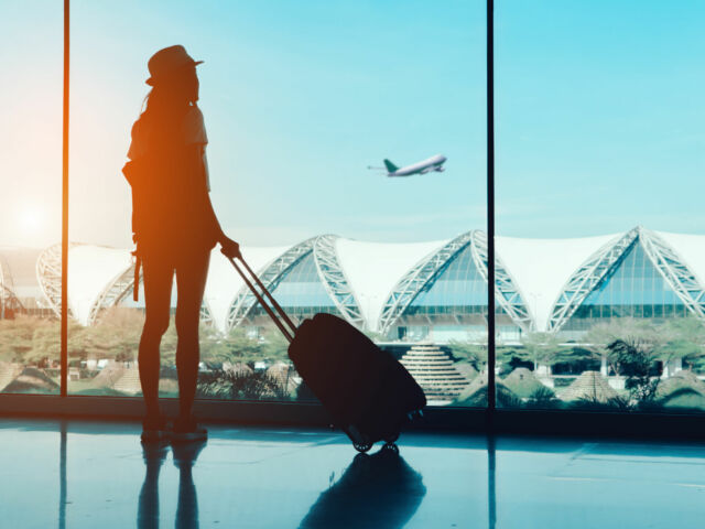 Silhouette,Woman,Travel,With,Luggage,Looking,Without,Window,At,Airport