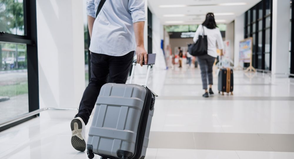 Asian,Businessman,Dragging,Luggage,In,The,Airport.