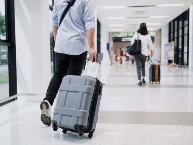 Asian,Businessman,Dragging,Luggage,In,The,Airport.