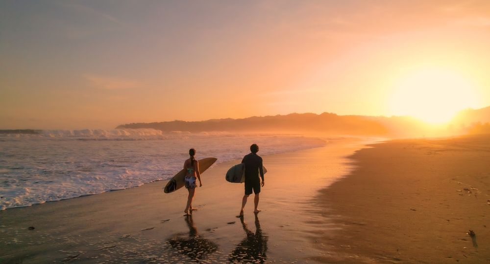 Aerial:,Surfers,Watch,Big,Breaking,Waves,From,Beach,After,Sunset