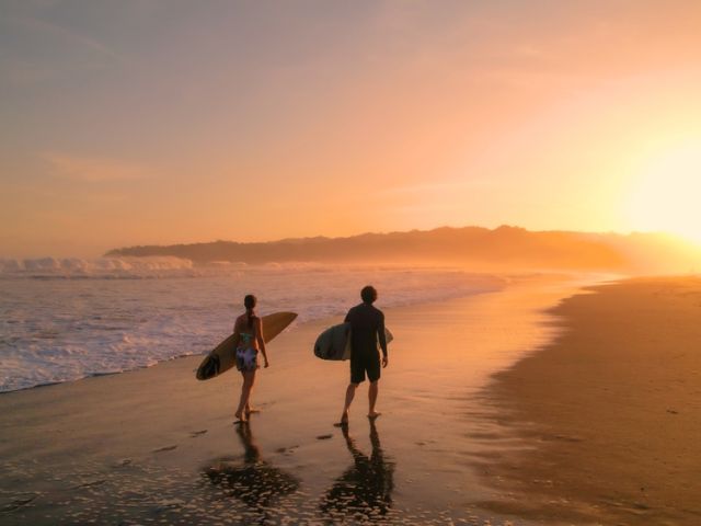 Aerial:,Surfers,Watch,Big,Breaking,Waves,From,Beach,After,Sunset